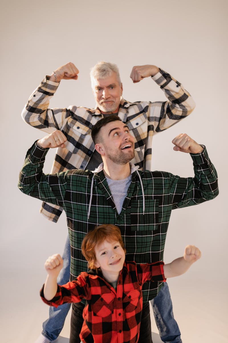 Family portrait of three generations flexing muscles in a studio.