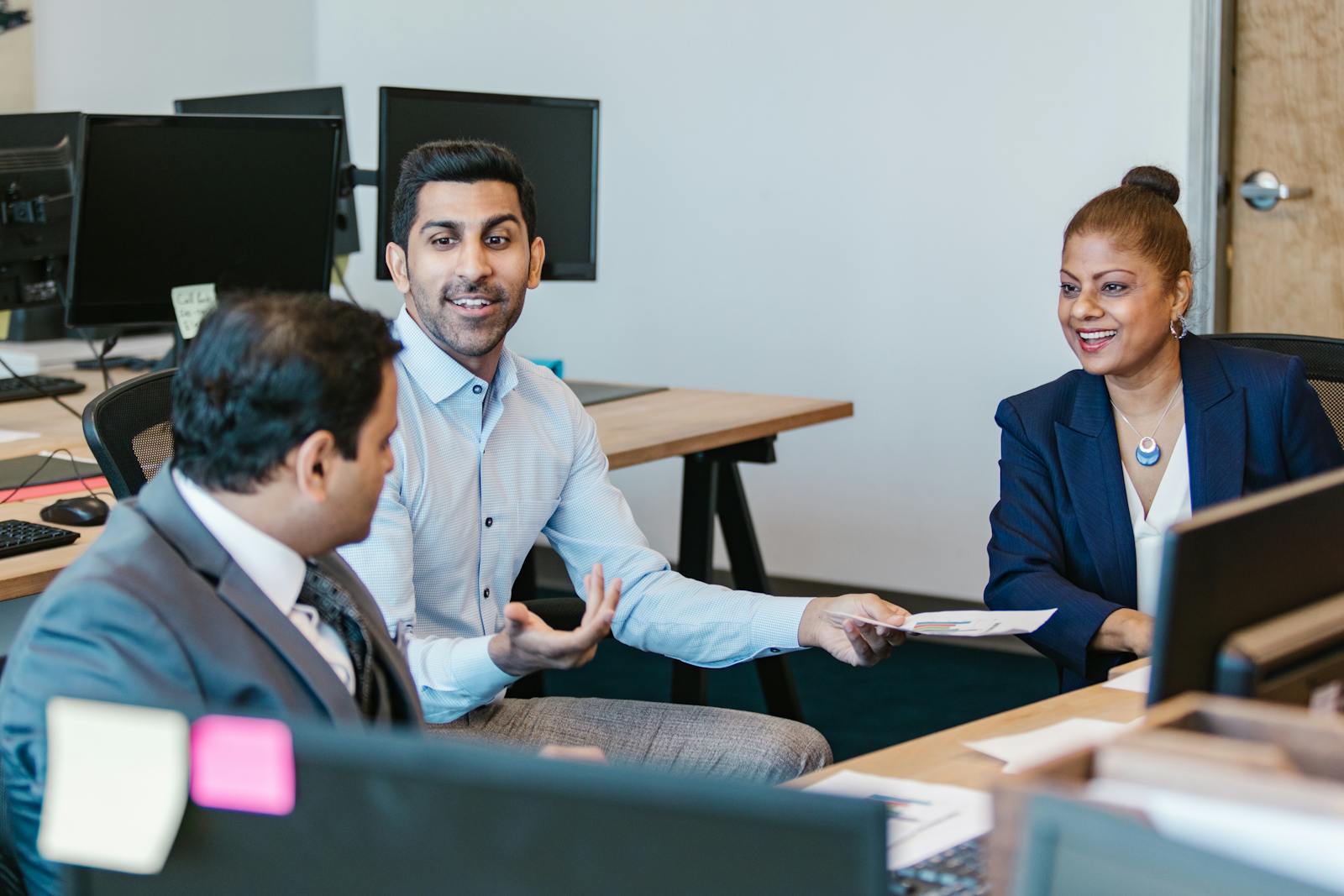 Colleagues engaging in a productive discussion in a modern office setting.